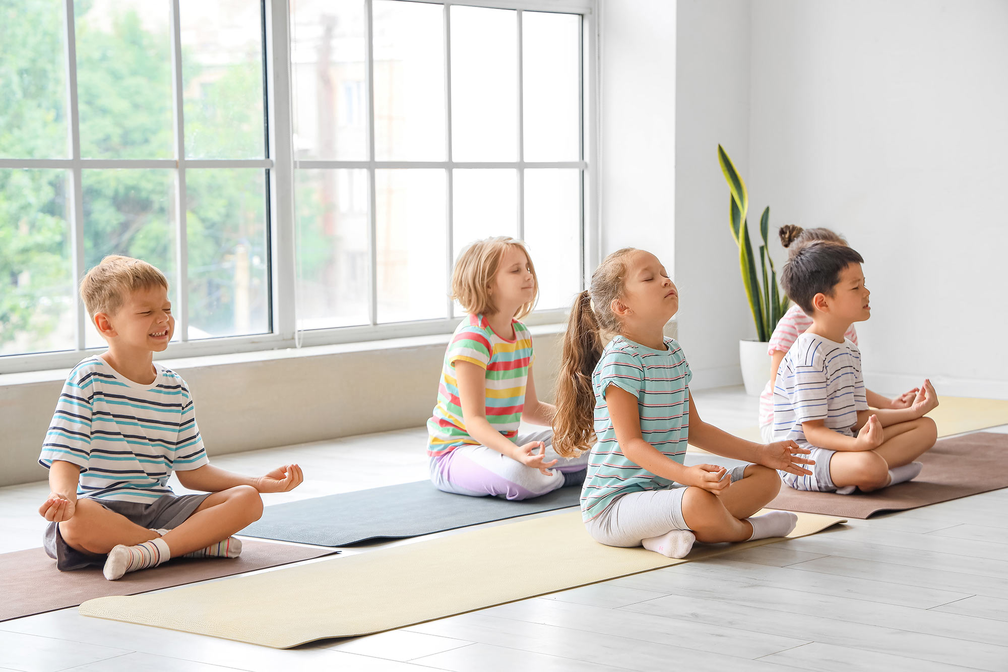 Kinder Kurs der meditiert auf dem Boden.