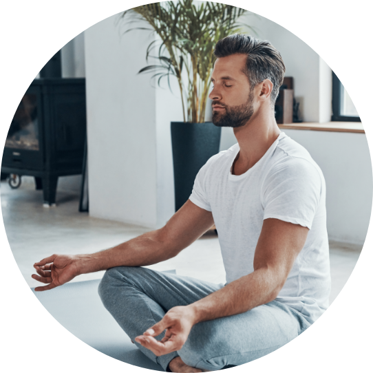 Man ca. 40 Jahre alt meditiert auf einer Yogamatte.