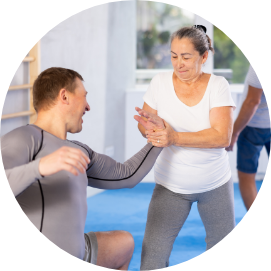 Seniorin_ (ca, 66 Jahre alt) trainiert Selbstverteidigung mit einem Mann (ca. 50 Jahre Alt)
