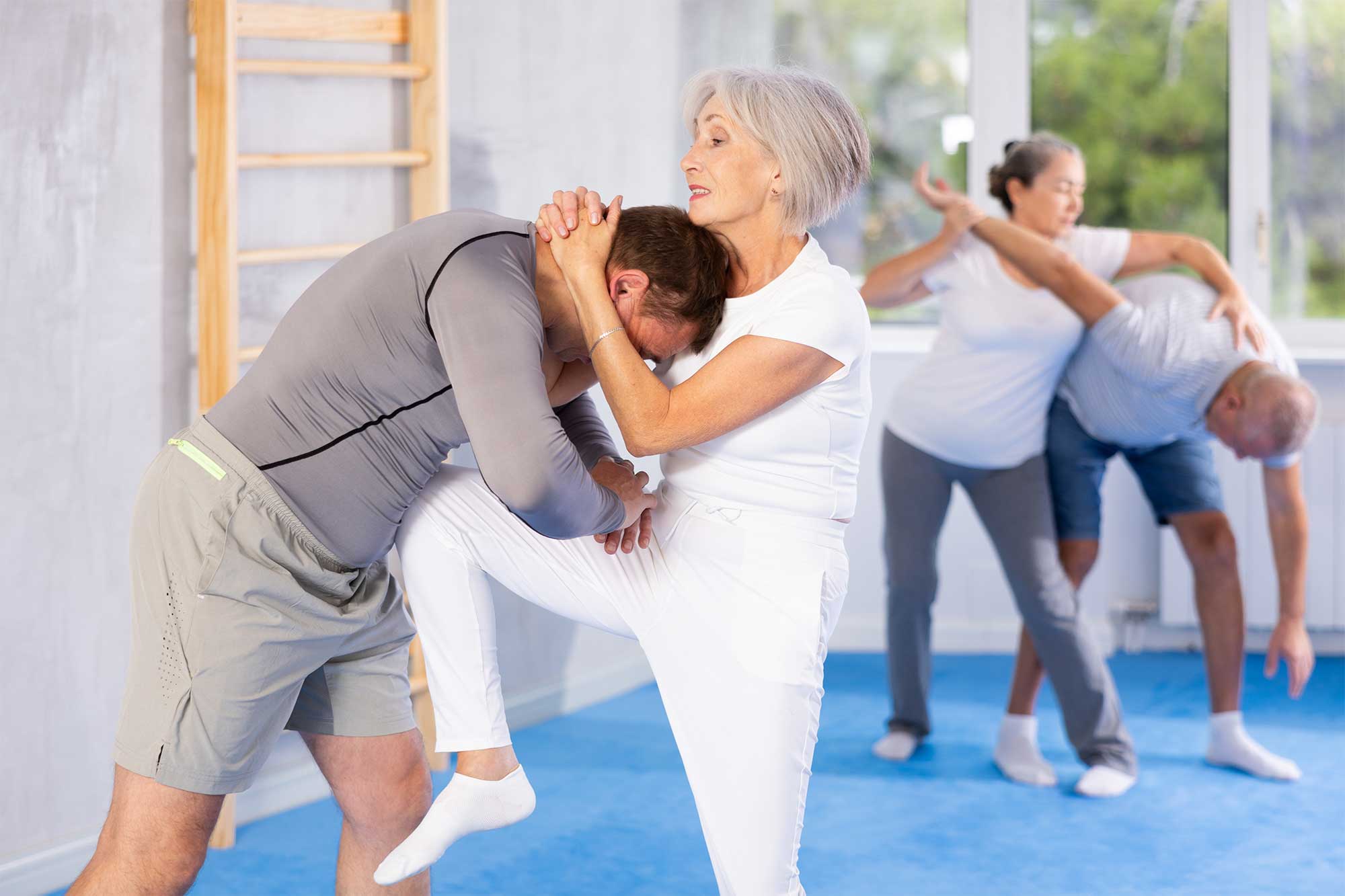 Seniorin (ca. 60 Jahre alt) übt Selbstverteidigungsgriff