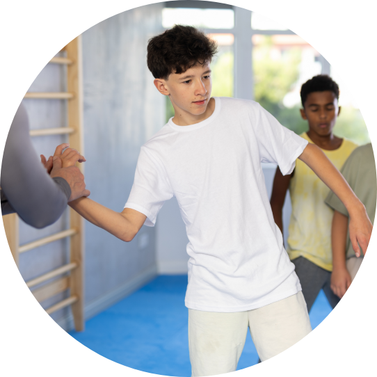 Trainer unterweist den Kurs mit einer neuen Griff Taktik und demonstriert diesen mit einem Jungen aus dem Kurs im Studio.